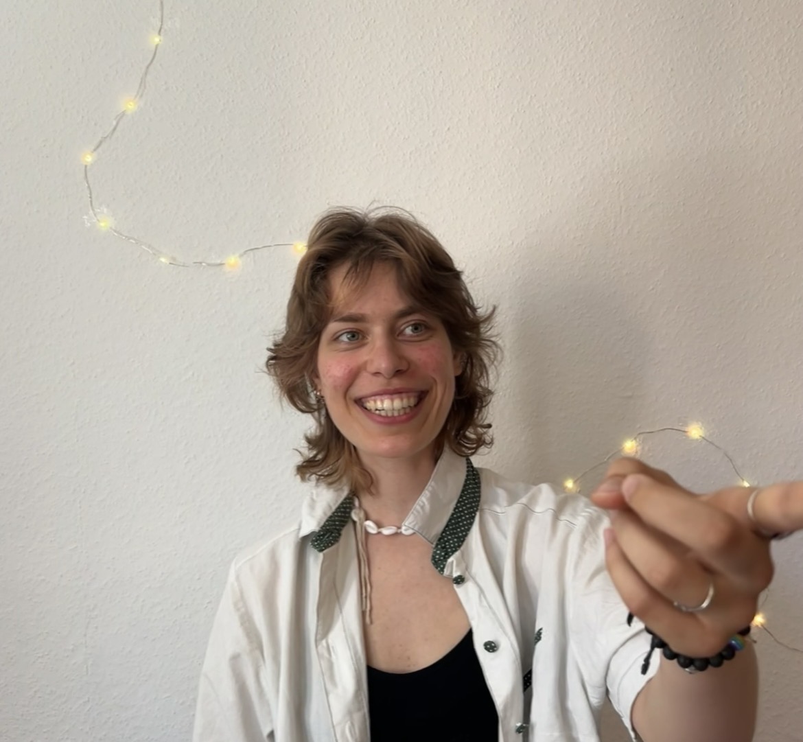 Anju, your German teacher, smiling with fairy lights